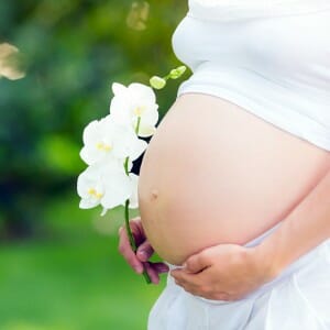 Беременная женщина с цветком