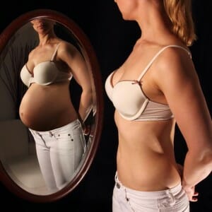 Беременная девушка только в зеркале