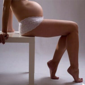 Беременная девушка сидит на стуле