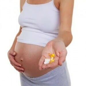Беременная с таблетками в руке
