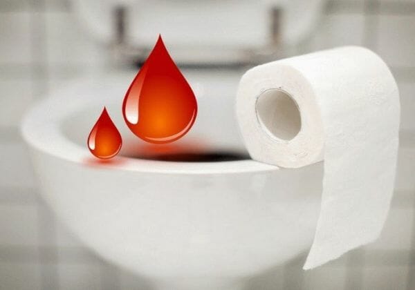 Туалетная бумага и красные капли на унитазе