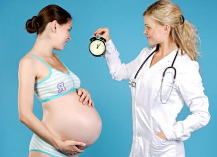 Беременная девушка и врач с часами